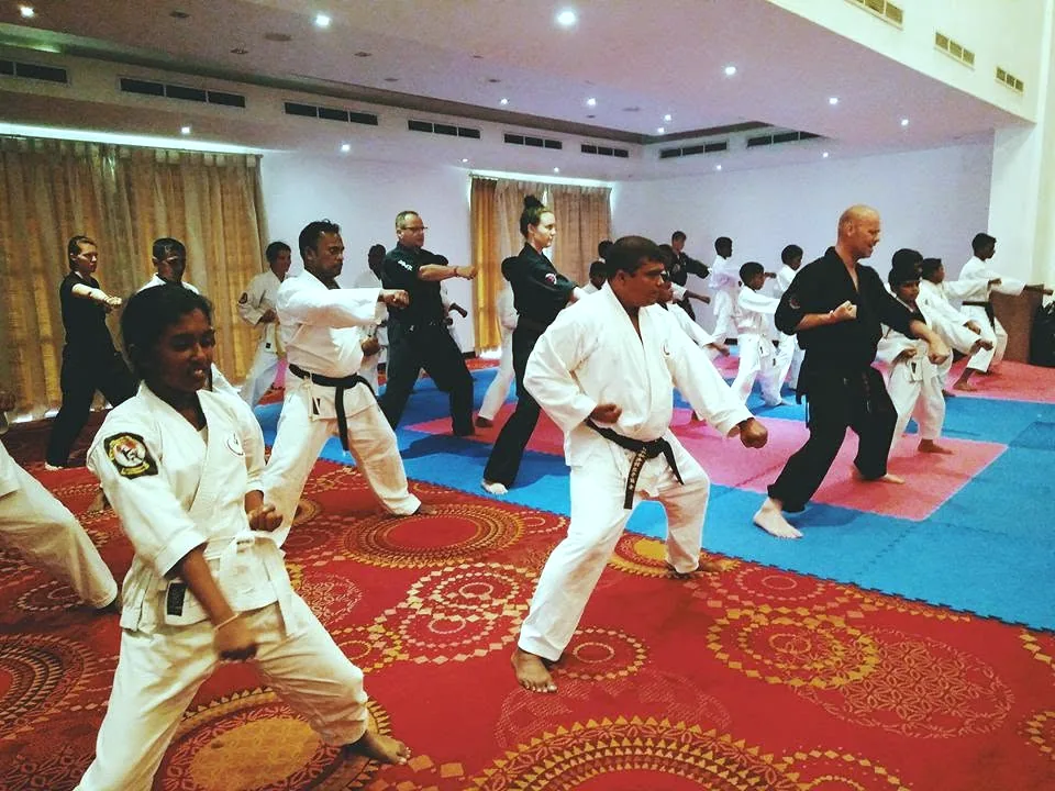 Karate students in white gis training on mats at the Budo-Camp