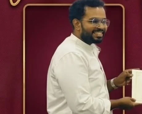 Jay smiling on stage holding a certificate after the Evaluation Contest