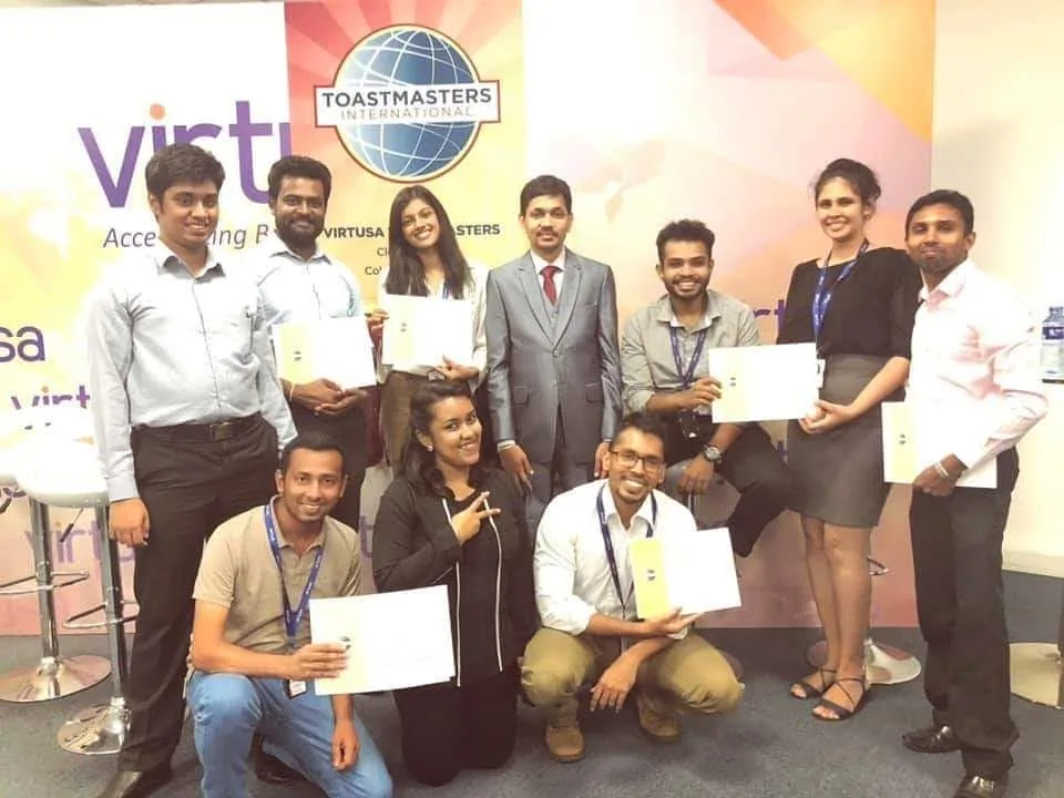 Contest participants holding certificates on the Virtusa Toastmasters stage