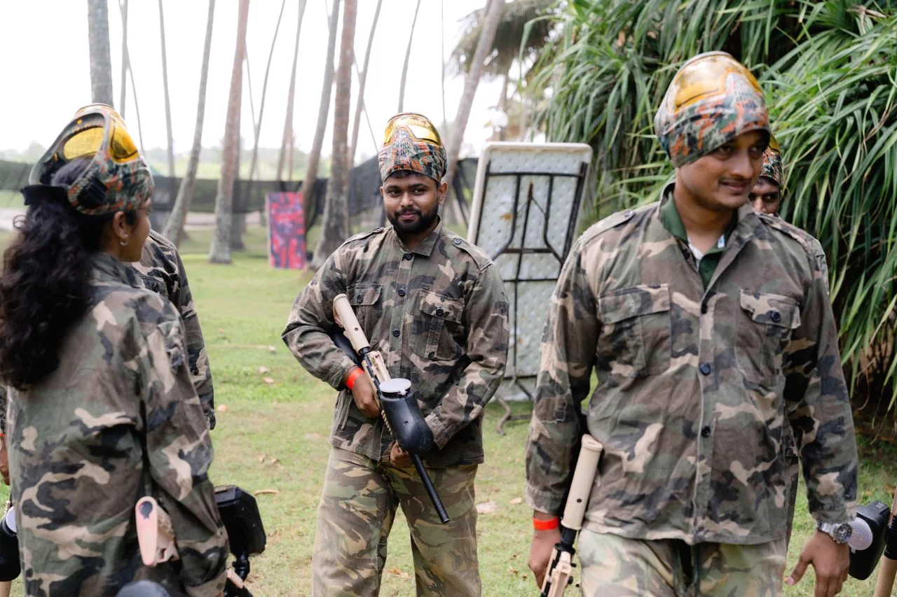 Colleagues in camouflage gear and helmets ready for paintball